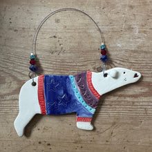 Load image into Gallery viewer, Decorative polar bear ornament with a colourful sweater on a wooden surface
