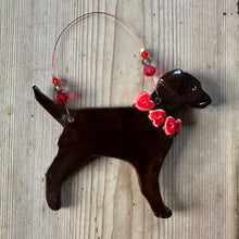 Load image into Gallery viewer, Decorative chocolate labrador -shaped ornament with red hearts on a textured surface