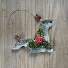 Load image into Gallery viewer, Decorative seal ornament with holly leaves and berries on a wooden surface