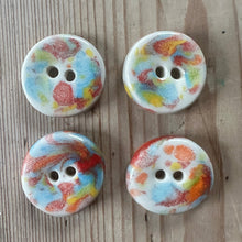 Load image into Gallery viewer, Four multi coloured ceramic buttons with a random pattern on a wooden surface