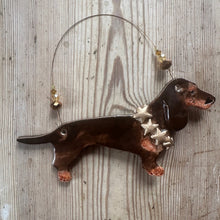 Load image into Gallery viewer, Decorative ceramic dachshund ornament with stars around its neck on a wooden surface