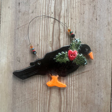 Load image into Gallery viewer, Decorative Cornish chough with holly leaves and berries on a wooden surface