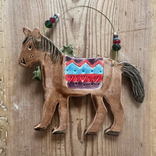 Load image into Gallery viewer, Ceramic horse figurine with decorative saddle on a wooden surface