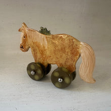 Load image into Gallery viewer, Ceramic horse ornament with wheels on a light background