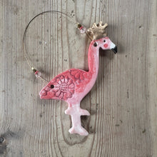 Load image into Gallery viewer, Decorative pink flamingo ornament with a gold crown on a wooden surface