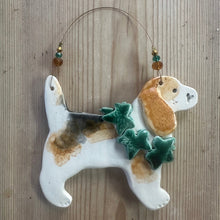 Load image into Gallery viewer, Decorative ceramic dog ornament with a green leaf on a wooden surface
