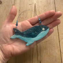 Load image into Gallery viewer, Decorative whale ornament held in a hand on a wooden surface