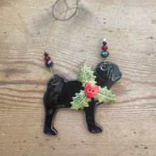 Load image into Gallery viewer, Decorative black dog ornament with holly leaves and berries on a wooden surface