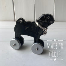 Load image into Gallery viewer, Black Pug "Woof on Wheels" ceramic ornament