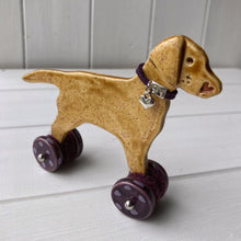Load image into Gallery viewer, Yellow Labrador Ceramic "Woof on Wheels" Ornament