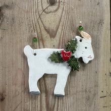 Load image into Gallery viewer, Decorative white goat ornament with holly leaves and berries on a wooden surface
