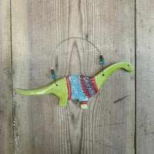 Load image into Gallery viewer, Decorative dinosaur figure with a colourful sweater on a wooden surface
