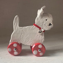 Load image into Gallery viewer, White dog figurine with red wheels on a light gray background
