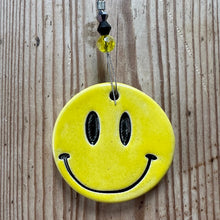 Load image into Gallery viewer, Yellow smiley face ornament on a wooden surface
