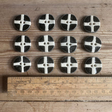 Load image into Gallery viewer, Black and white buttons arranged in a grid on a wooden surface with a ruler for scale.
