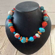 Load image into Gallery viewer, Colourful beaded bracelet on a black bust against a wooden background
