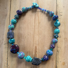 Load image into Gallery viewer, Multi-coloured beaded necklace on a wooden surface
