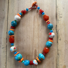 Load image into Gallery viewer, Colourful bead necklace on a wooden surface
