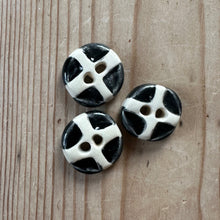 Load image into Gallery viewer, Three black and white buttons on a wooden surface
