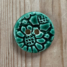 Load image into Gallery viewer, Green ceramic button with floral design on a wooden surface
