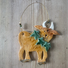 Load image into Gallery viewer, Decorative ceramic coo ornament with green leaves on a wooden surface
