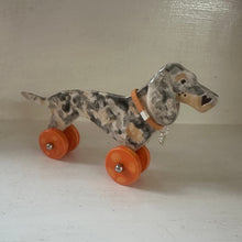 Load image into Gallery viewer, ceramic dog with orange wheels on a plain background
