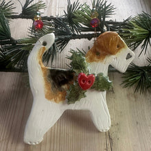 Load image into Gallery viewer, Decorative ornament shaped like a dog with holly on a wooden surface
