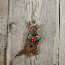 Load image into Gallery viewer, Decorative ornament shaped like a dog with a Christmas wreath on a wooden surface
