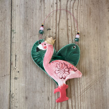 Load image into Gallery viewer, Decorative ceramic flamingo with floral design on a wooden surface
