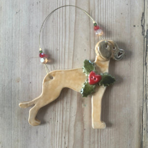 Dog-shaped ornament with holly on a wooden surface