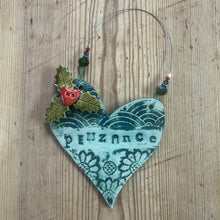 Load image into Gallery viewer, Decorative heart-shaped ornament with holly leaves and berries on a wooden surface
