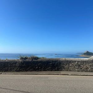 Road leading to a coastal landscape with a clear blue sky