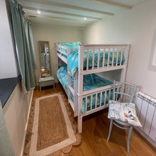 Load image into Gallery viewer, Bunk bed with blue bedding in a room with wooden floor and white walls.
