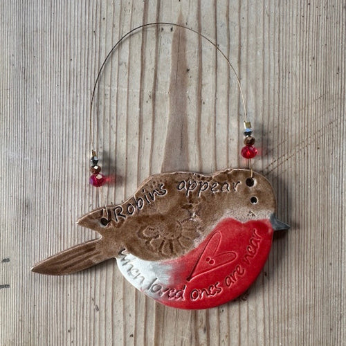 Decorative wall hanging with a bird design on a wooden surface