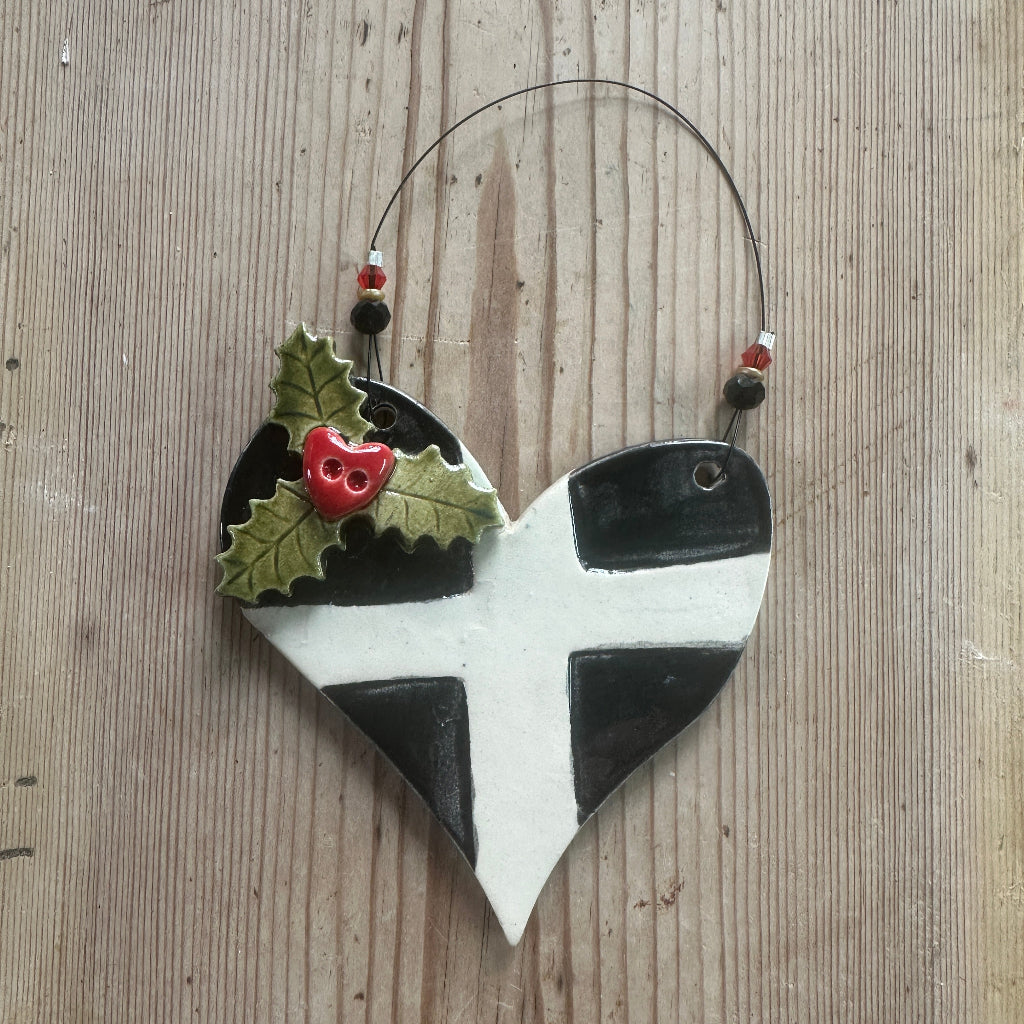Decorative ornament with black and white  Cornish St Piran's Flag design on a wooden surface