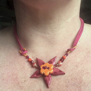 Flower necklaces on suede being worn