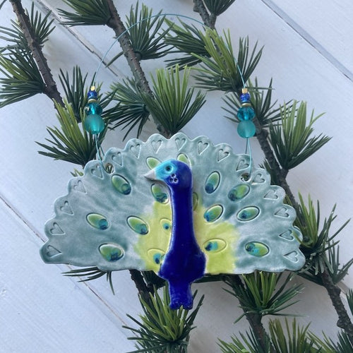 Ceramic peacock decoration strung on wire with colour coordinating beads